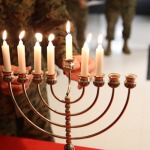 Capt. Irving Elson, a chaplain with I Marine Expeditionary Force, returns the shamash, or "attendant" candle to the menorah after its use aboard Marine Corps Air Station Miramar, Calif., Dec. 2. The shamash was used to light the other candles as one of the many holiday traditions in Hanukkah.